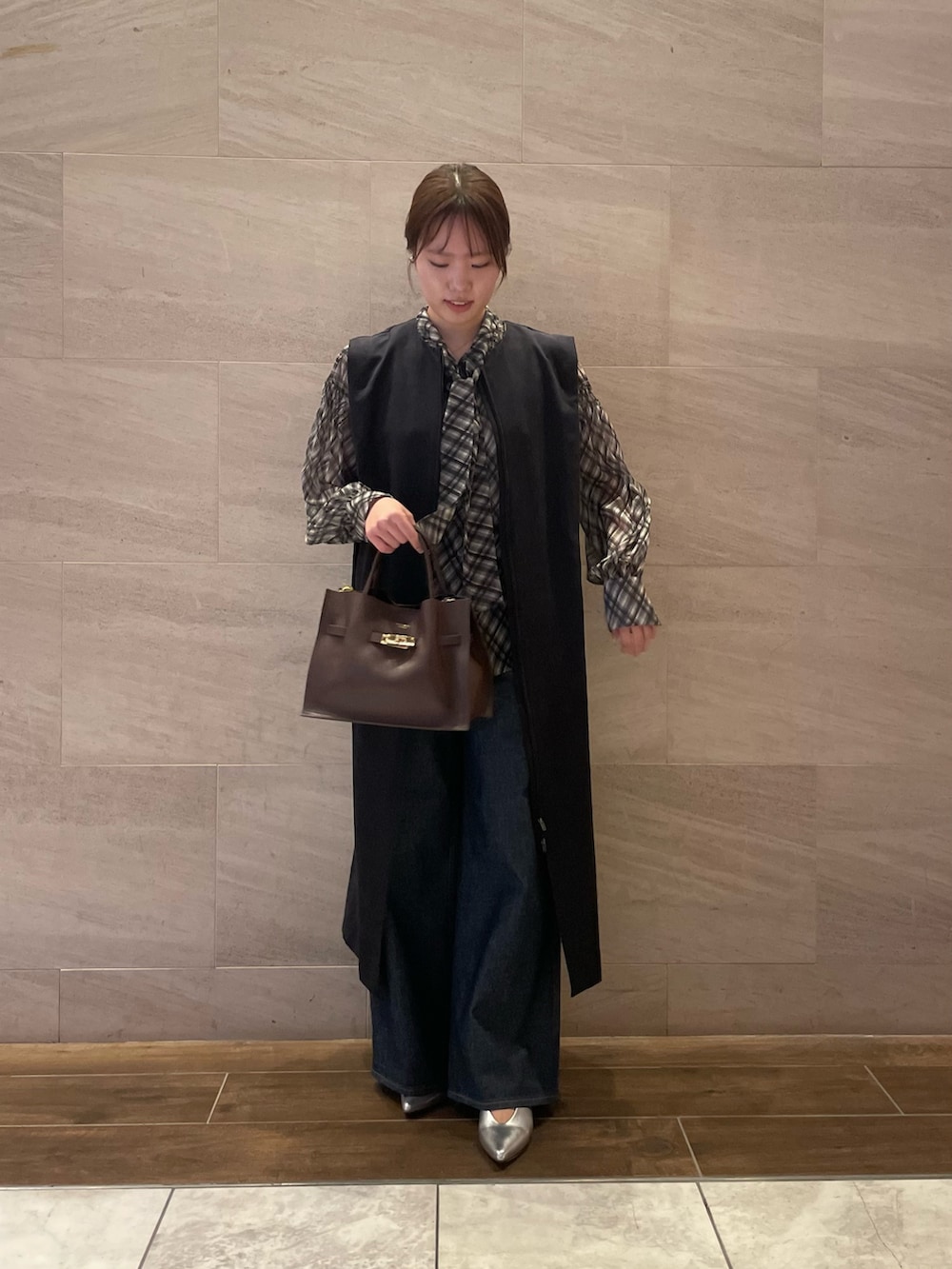 ブラック系のシャツ/ブラウス、ブルー系のワンピース、ブラウン系のトートバッグを着用したレディースの秋コーディネートの2枚目の写真