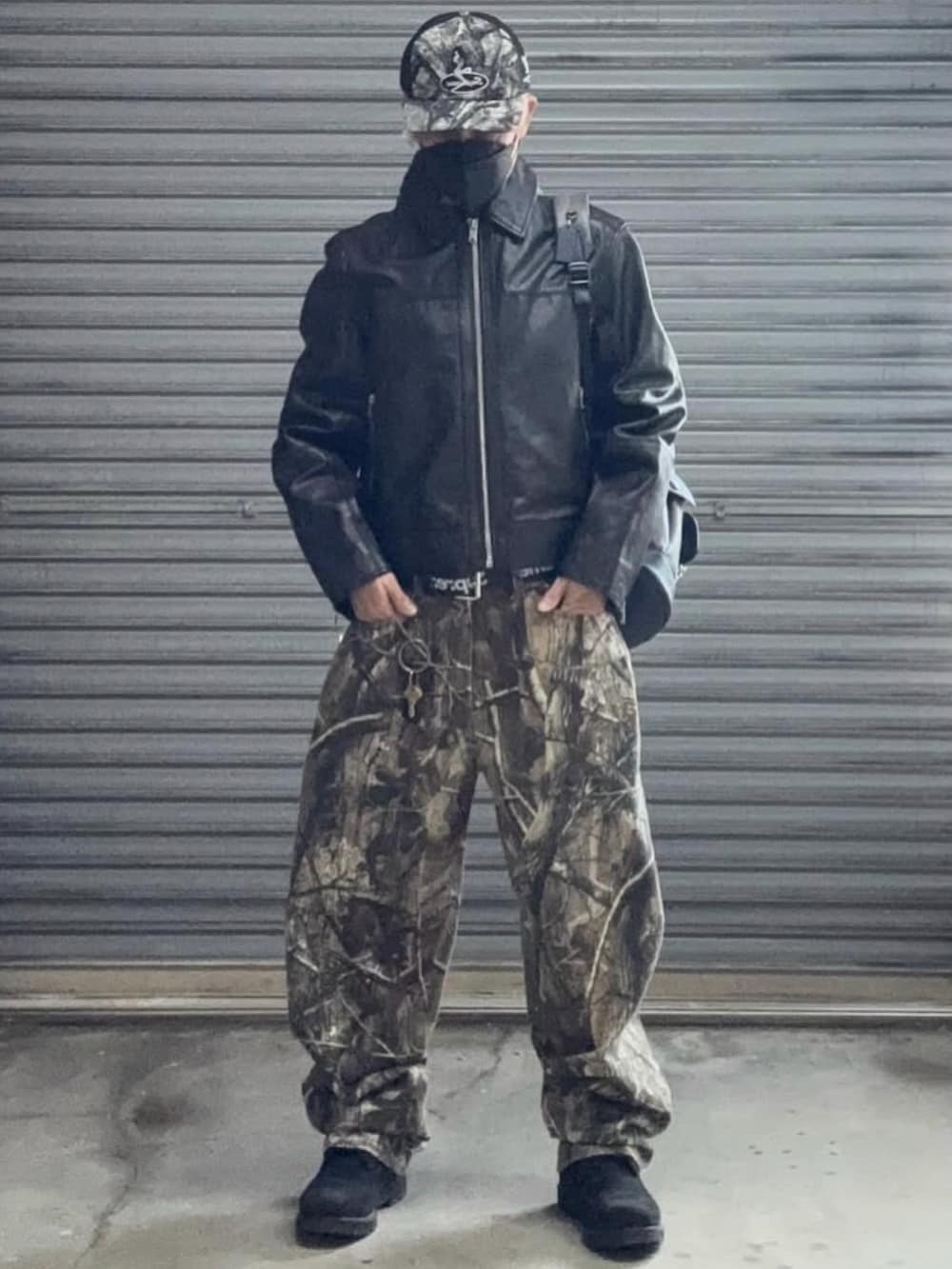 ブラック系のライダースジャケット、グリーン系のデニムパンツ、ブラック系のブーツを着用したメンズの冬コーディネートの4枚目の写真