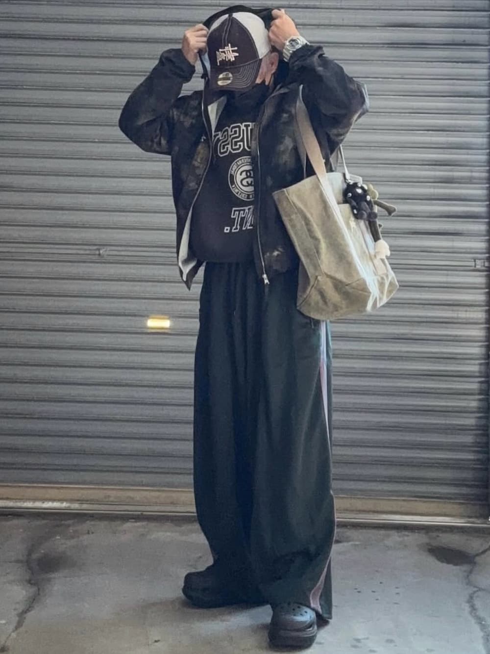 グリーン系のナイロンジャケット、ブラック系のスウェット、グリーン系のその他パンツを着用したメンズの冬コーディネートの2枚目の写真