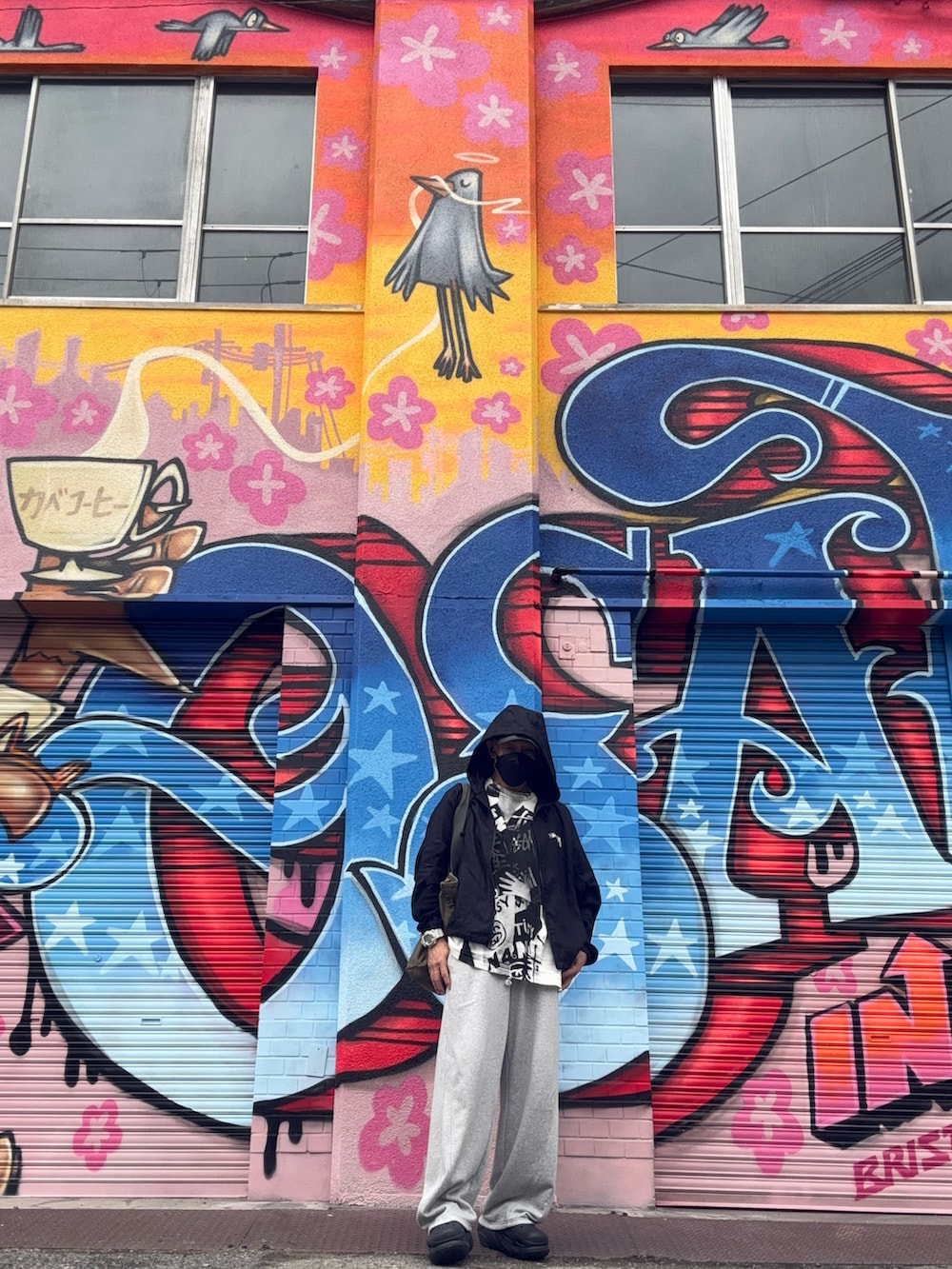 グレー系のスウェットパンツ、ブラック系のナイロンジャケット、ブラック系のサンダルを着用したメンズの冬コーディネートの4枚目の写真