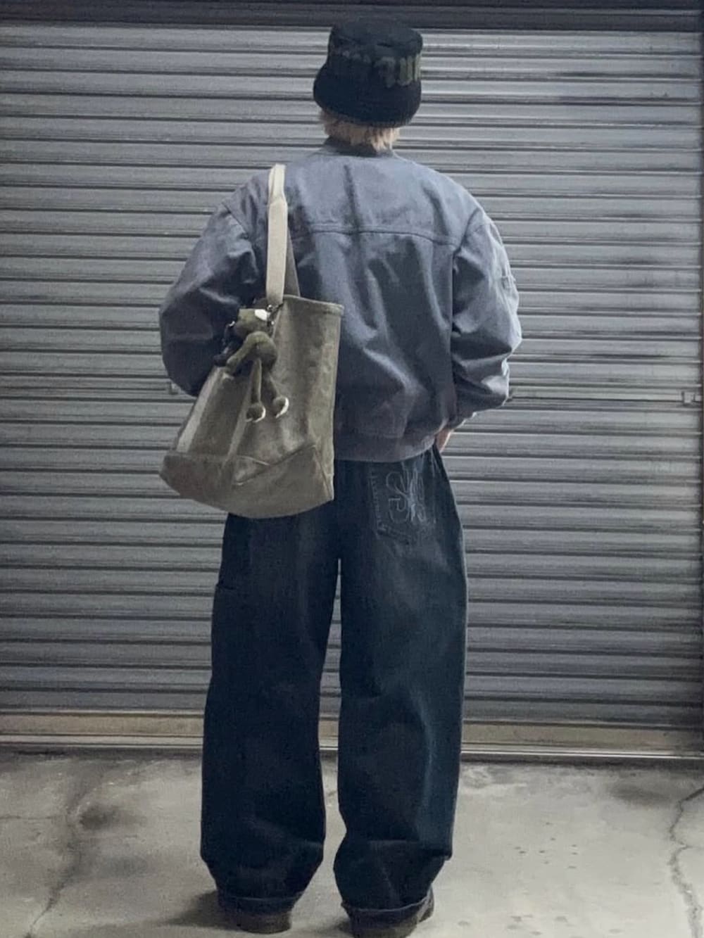 ブルー系のMA-1、ブルー系のデニムパンツ、グレー系のニット/セーターを着用したメンズの冬コーディネートの3枚目の写真