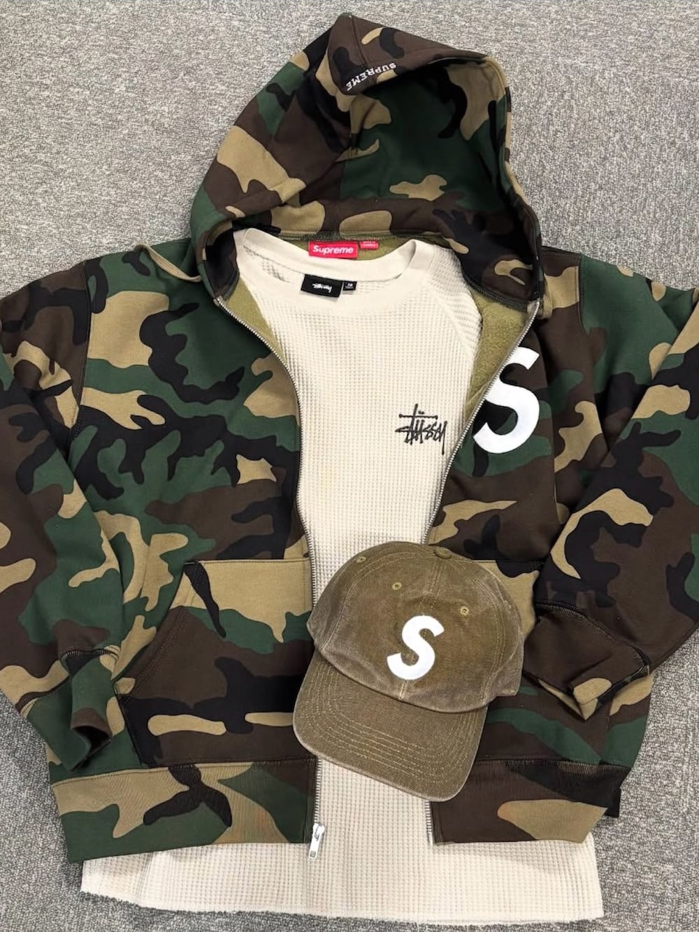 ベージュ系のパーカー、ブラック系のスラックス、ベージュ系のキャップを着用したメンズの冬コーディネートの5枚目の写真