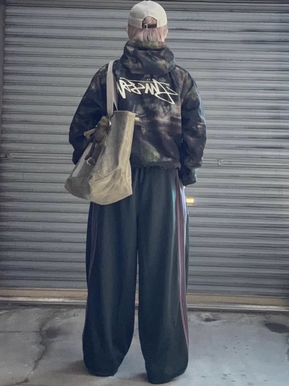 グリーン系のナイロンジャケット、ブラック系のスウェット、グリーン系のその他パンツを着用したメンズの冬コーディネートの3枚目の写真