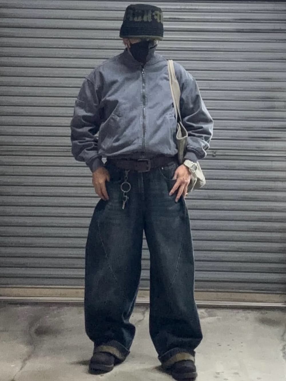 ブルー系のMA-1、ブルー系のデニムパンツ、グレー系のニット/セーターを着用したメンズの冬コーディネートの4枚目の写真