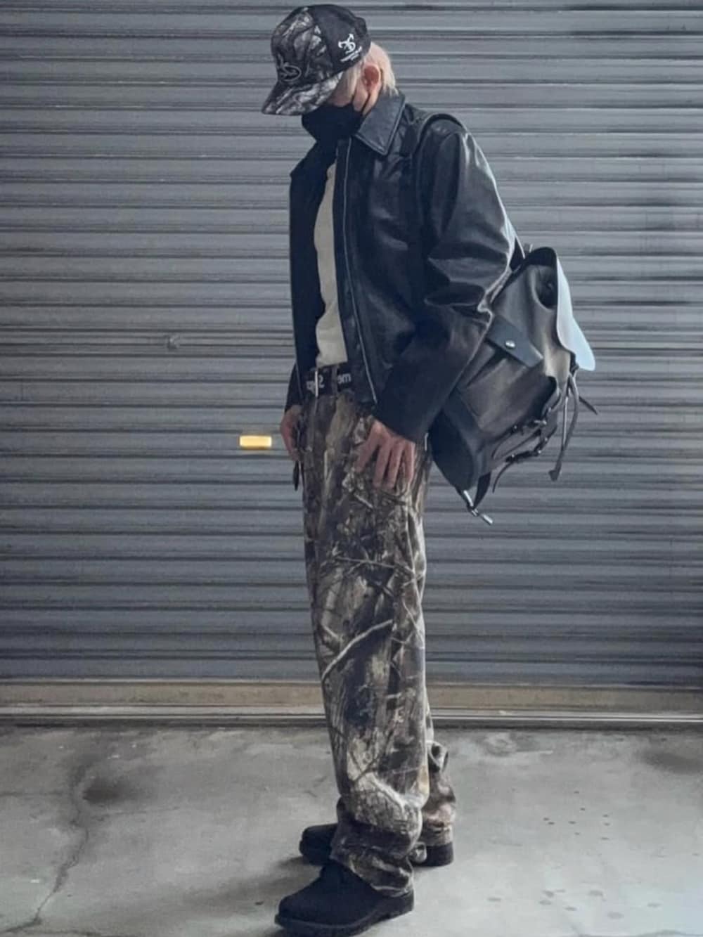 ブラック系のライダースジャケット、グリーン系のデニムパンツ、ブラック系のブーツを着用したメンズの冬コーディネートの2枚目の写真