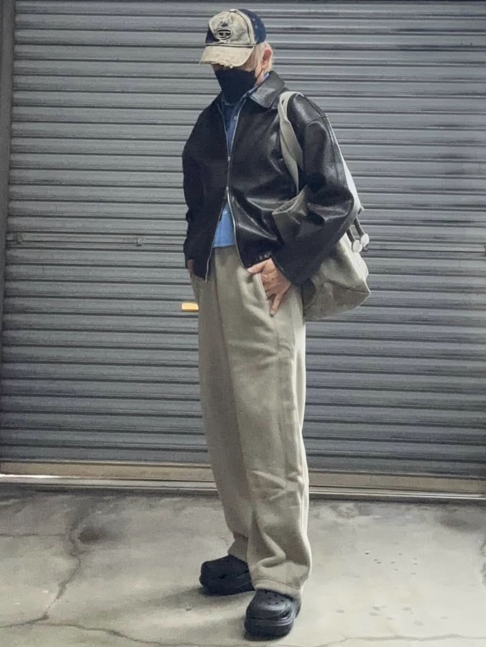 ブラック系のブルゾン、ベージュ系のスウェットパンツ、ブラック系のサンダルを着用したメンズの冬コーディネートの2枚目の写真