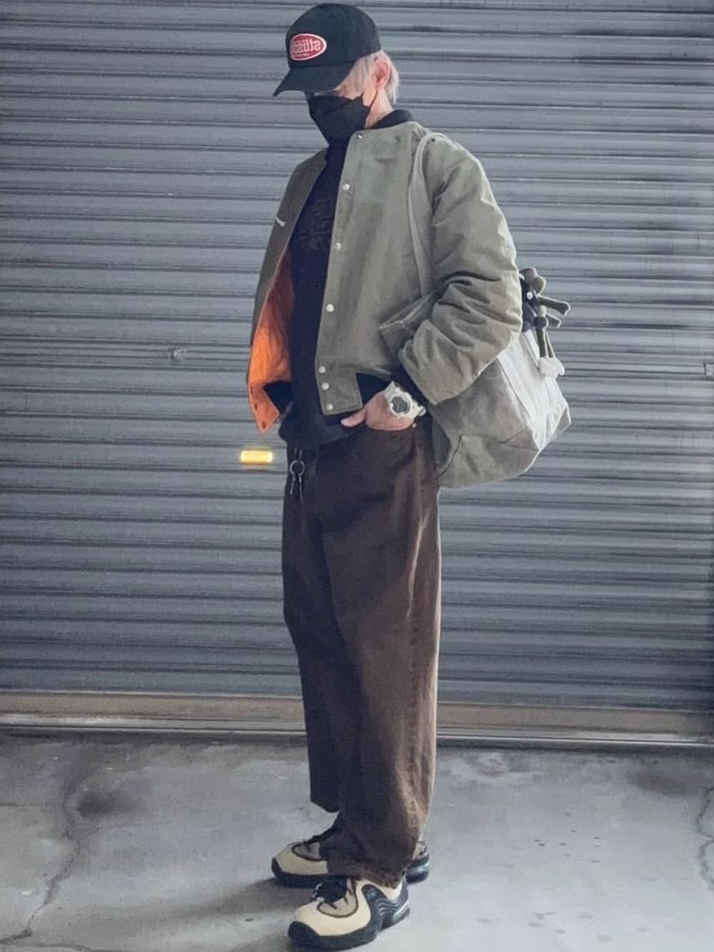 グリーン系のMA-1、ブラック系のTシャツ/カットソー、ブラウン系のデニムパンツを着用したメンズの冬コーディネートの2枚目の写真