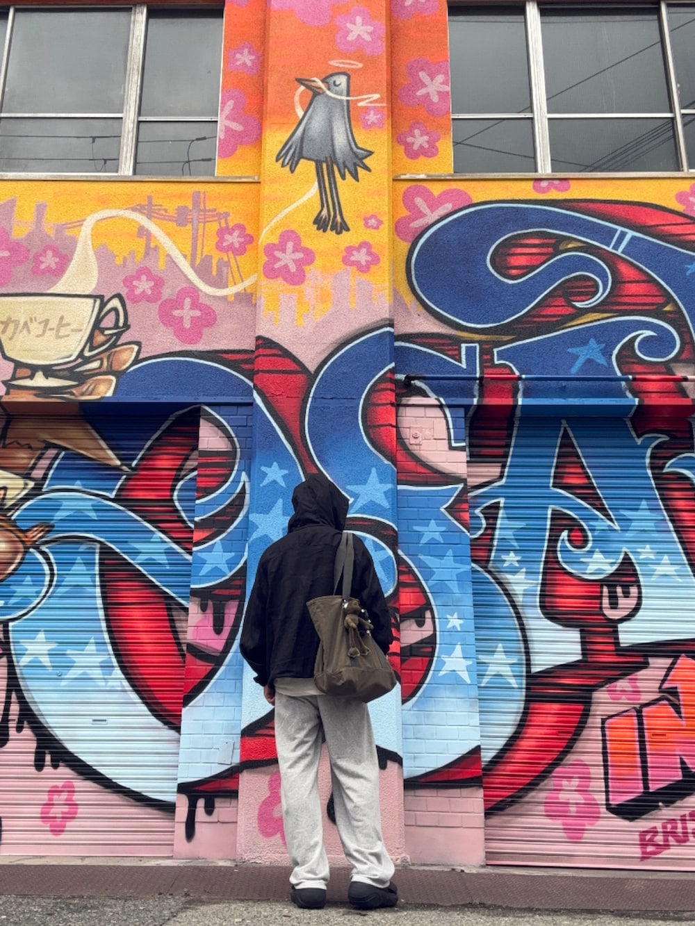 グレー系のスウェットパンツ、ブラック系のナイロンジャケット、ブラック系のサンダルを着用したメンズの冬コーディネートの3枚目の写真