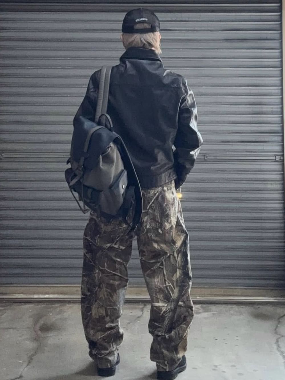 ブラック系のライダースジャケット、グリーン系のデニムパンツ、ブラック系のブーツを着用したメンズの冬コーディネートの3枚目の写真