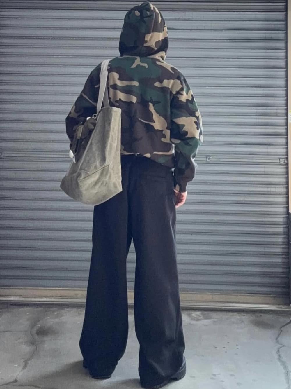 ベージュ系のパーカー、ブラック系のスラックス、ベージュ系のキャップを着用したメンズの冬コーディネートの4枚目の写真