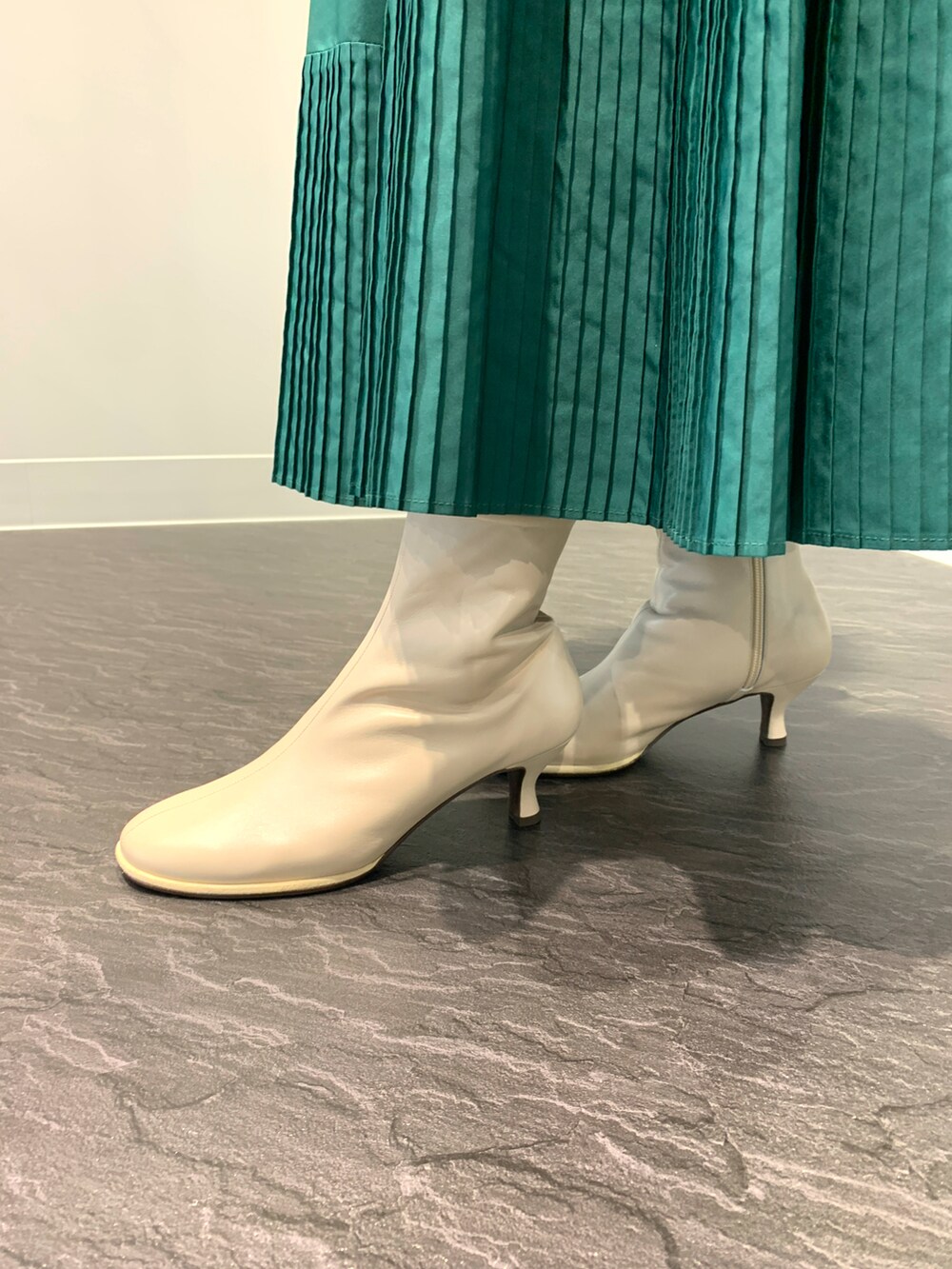 ホワイト系のブーツを着用したレディースの秋コーディネートの2枚目の写真