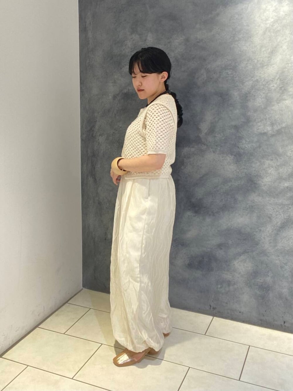 ホワイト系のその他パンツ、ホワイト系のベスト、ホワイト系のニット/セーターを着用したレディースの春コーディネートの2枚目の写真