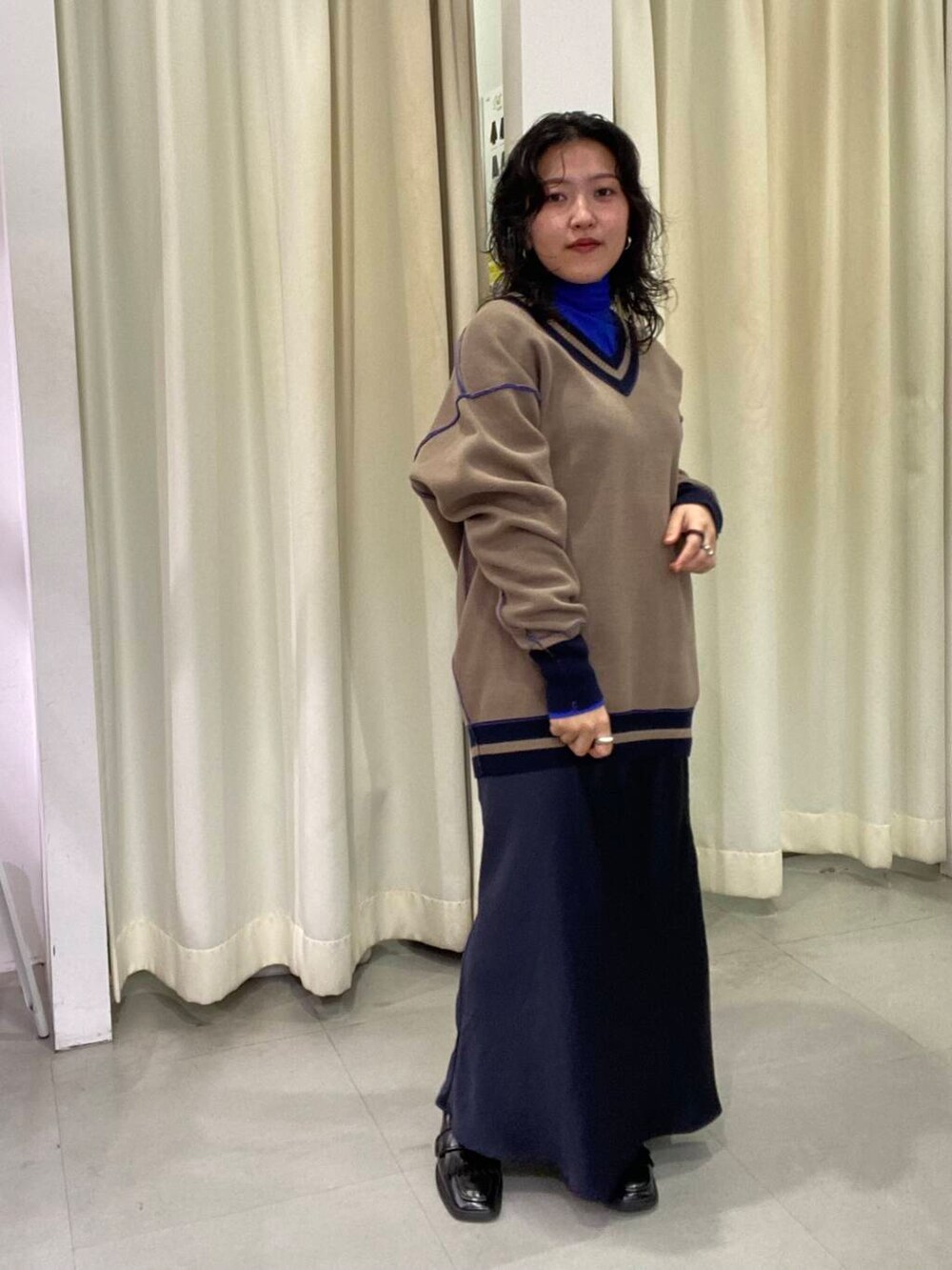 ブルー系のスカート、ブラック系のローファー、ブルー系のTシャツ/カットソーを着用したレディースの秋コーディネートの2枚目の写真