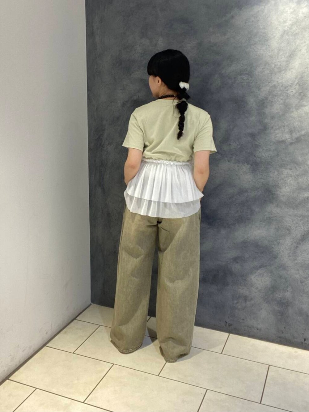 イエロー系のパンプス、グリーン系のTシャツ/カットソー、グリーン系のデニムパンツを着用したレディースの春コーディネートの3枚目の写真