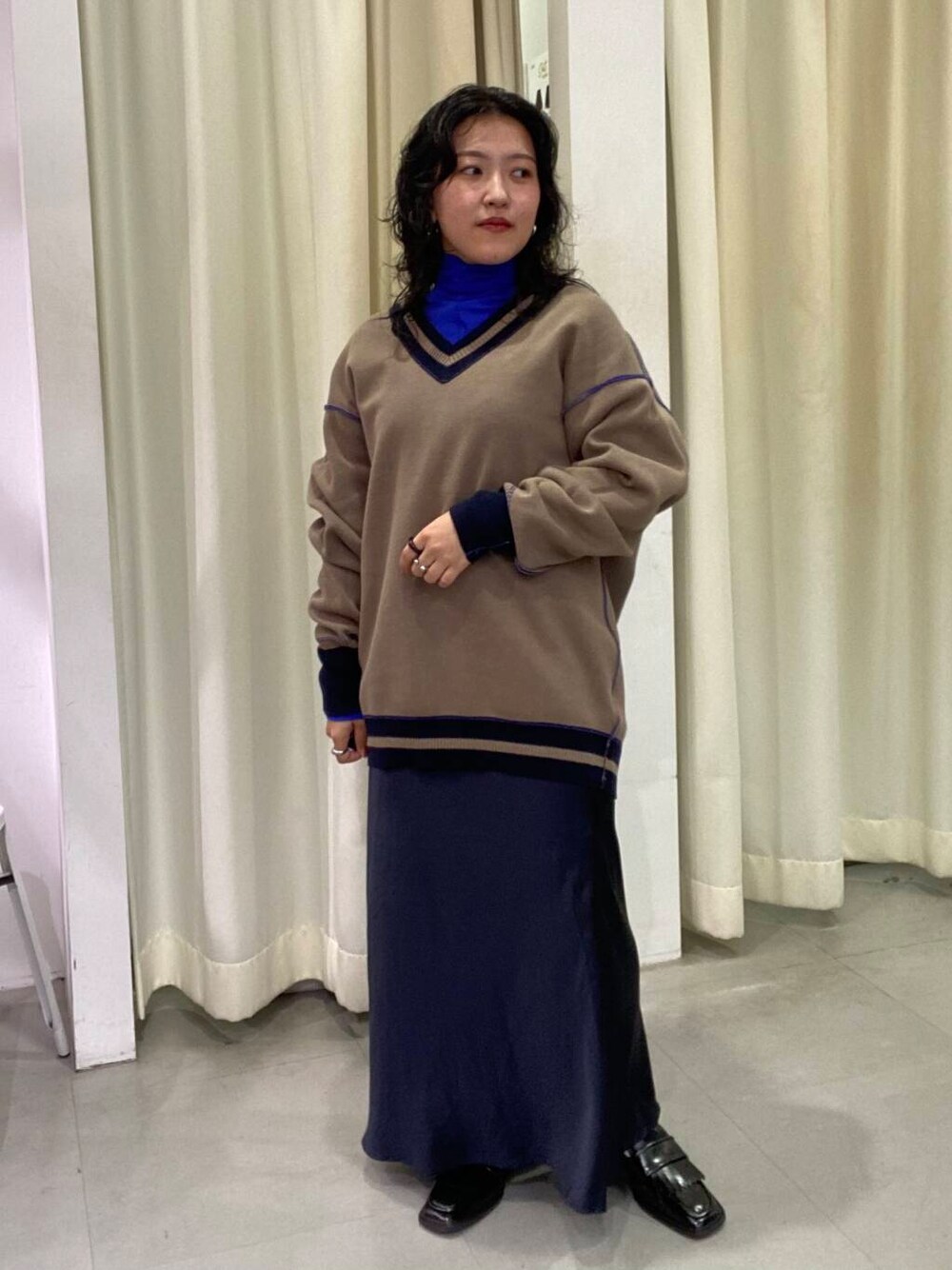 ブルー系のスカート、ブラック系のローファー、ブルー系のTシャツ/カットソーを着用したレディースの秋コーディネートの3枚目の写真