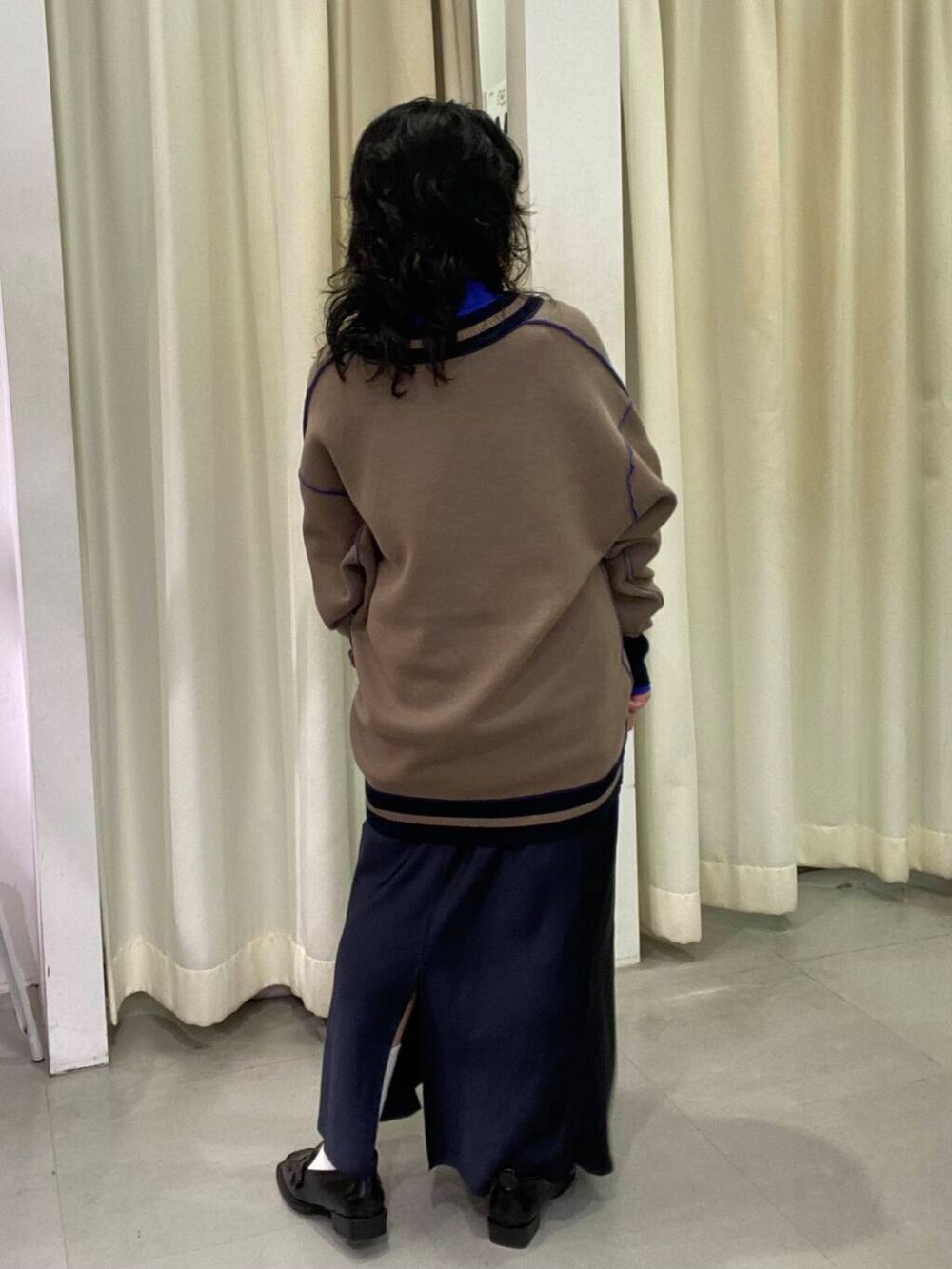 ブルー系のスカート、ブラック系のローファー、ブルー系のTシャツ/カットソーを着用したレディースの秋コーディネートの5枚目の写真