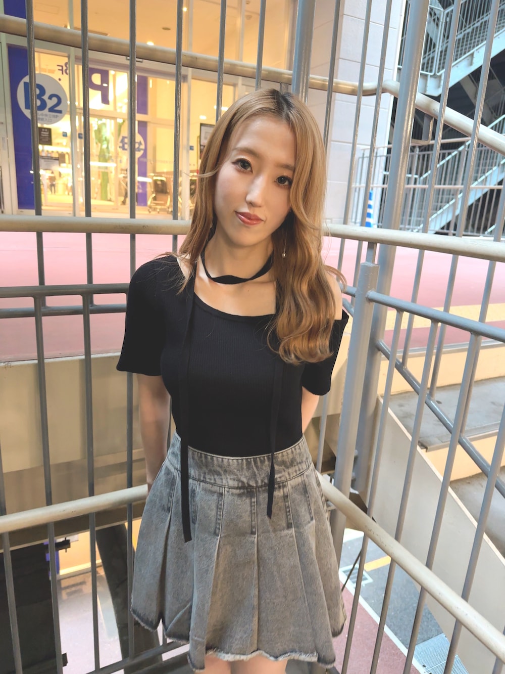 ブラック系のニット/セーター、ブルー系のスカート、ブラック系のサンダルを着用したレディースの夏コーディネートの2枚目の写真