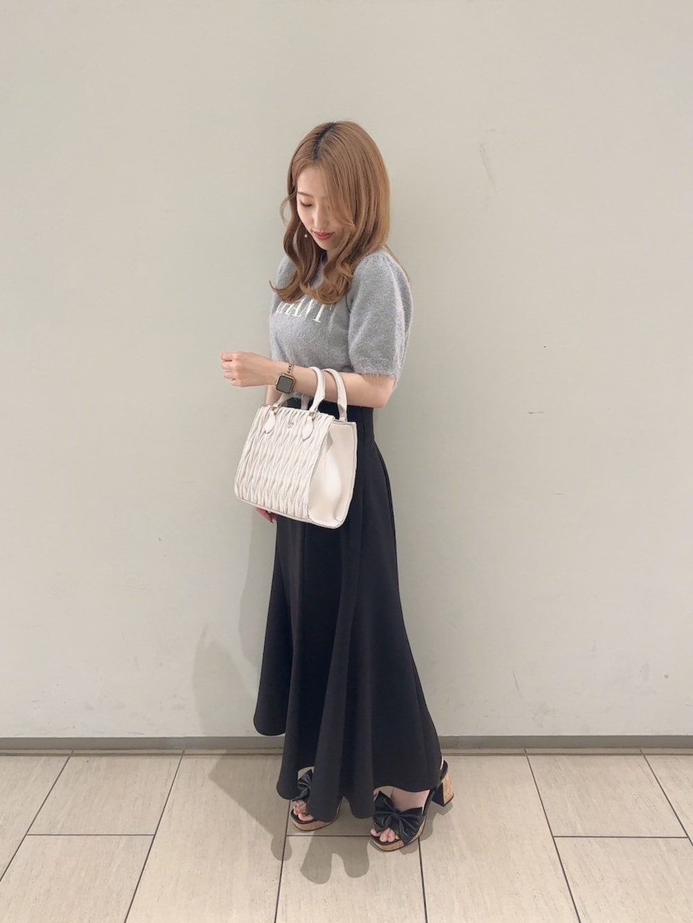 グレー系のニット/セーター、ブラック系のスカート、ブラック系のサンダルを着用したレディースの夏コーディネートの3枚目の写真