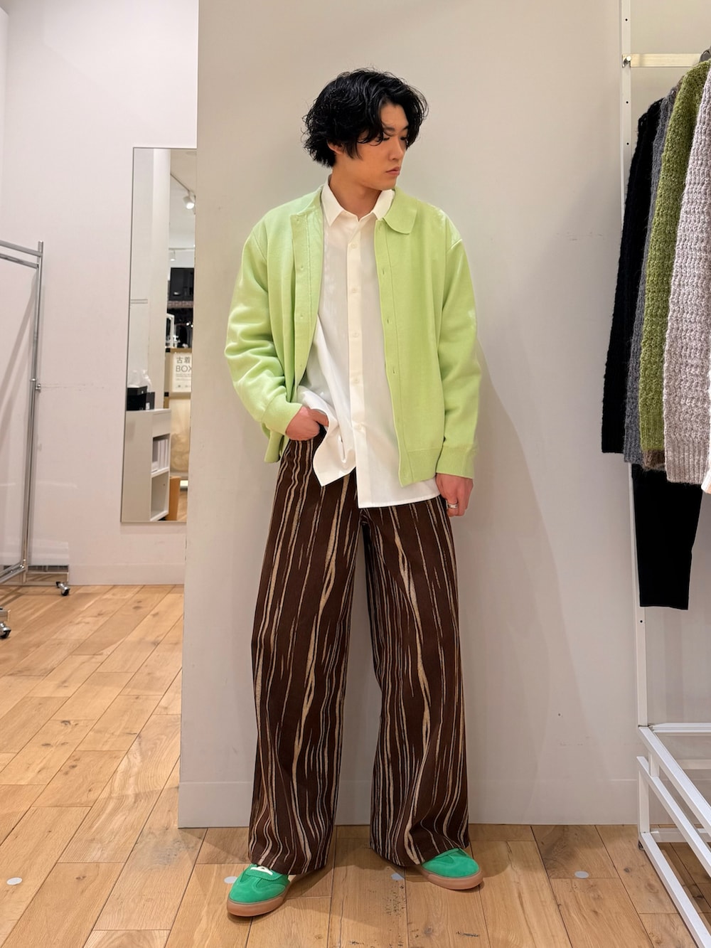 グリーン系のカーディガン/ボレロ、ホワイト系のシャツ/ブラウス、ブラウン系のデニムパンツを着用したメンズの春コーディネートの3枚目の写真