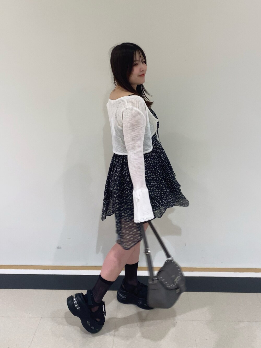 ブラック系のワンピース、ホワイト系のカーディガン/ボレロを着用したレディースの夏コーディネートの2枚目の写真