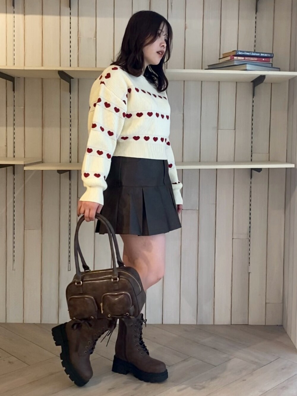 ホワイト系のニット/セーター、ブラウン系のスカート、ブラウン系のショルダーバッグを着用したレディースの秋コーディネートの2枚目の写真