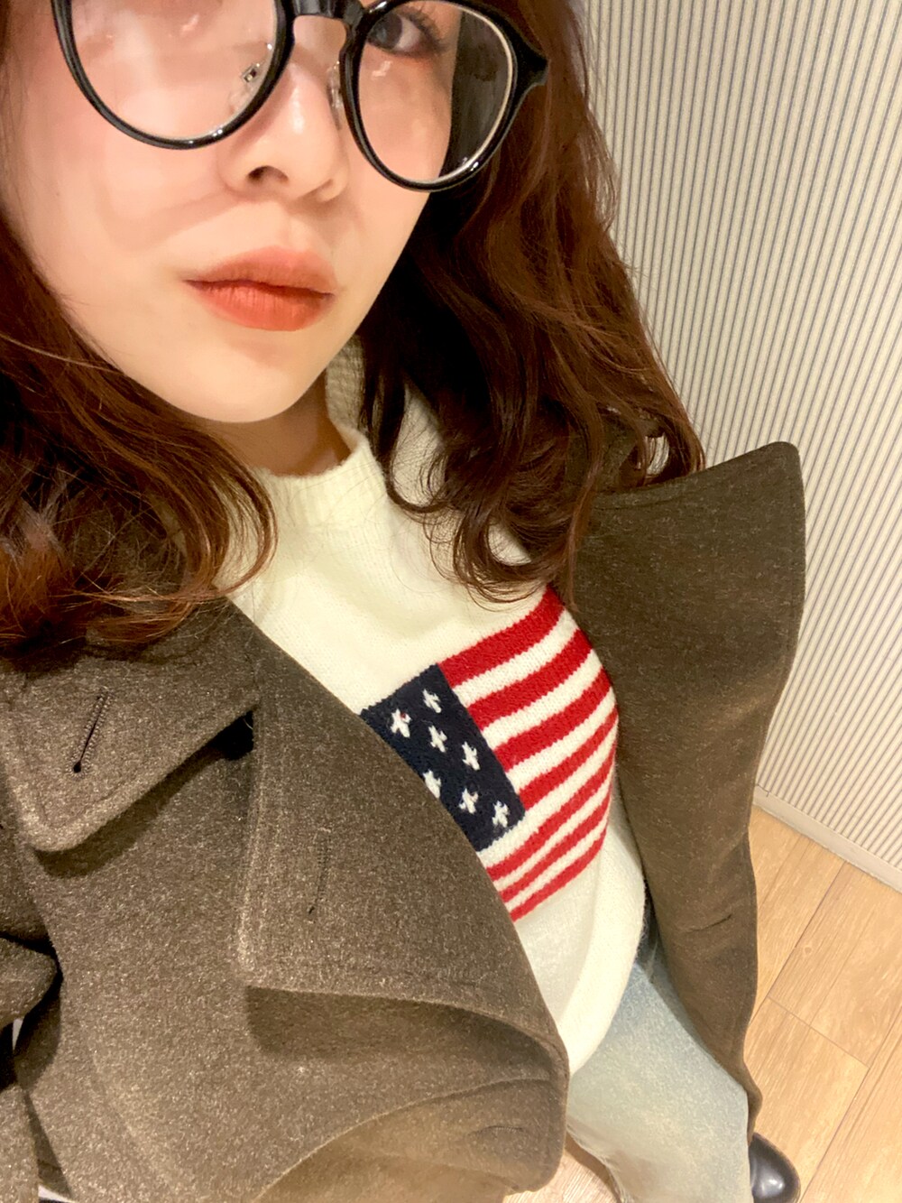 グレー系のショルダーバッグ、ブラウン系のその他アウター、ホワイト系のニット/セーターを着用したレディースの冬コーディネートの2枚目の写真