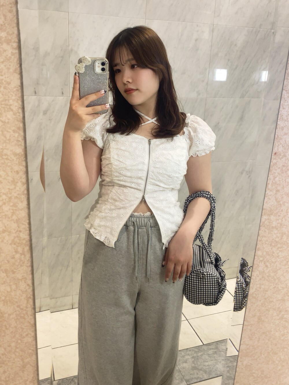 ホワイト系のシャツ/ブラウス、グレー系のパンツ、ブラック系のショルダーバッグを着用したレディースの春コーディネートの2枚目の写真