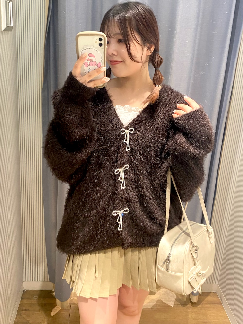 ブラウン系のカーディガン/ボレロ、ベージュ系のスカート、ホワイト系のショルダーバッグを着用したレディースの秋コーディネートの4枚目の写真