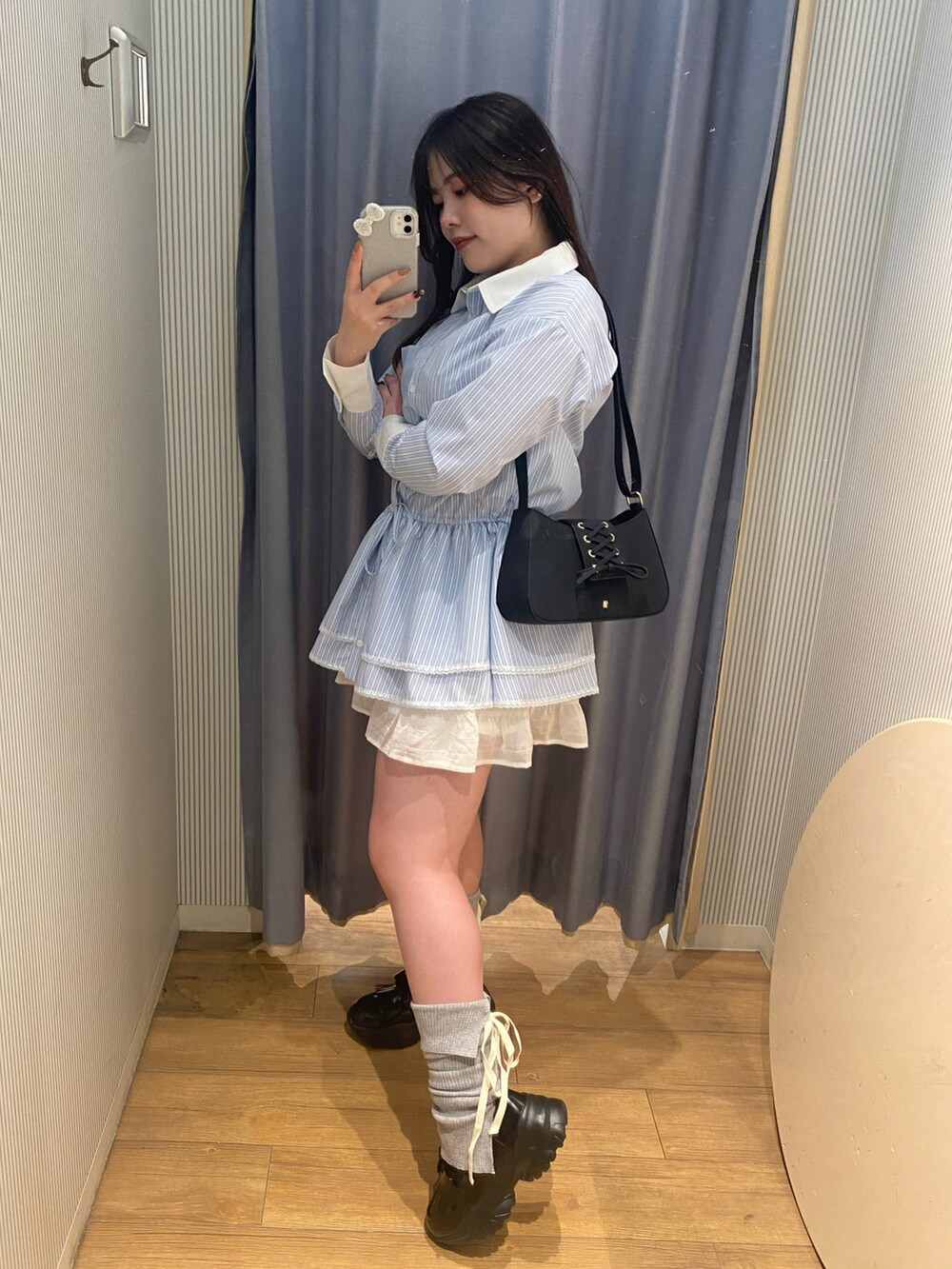 グレー系のニット/セーター、ブルー系のチュニック、ブラック系のショルダーバッグを着用したレディースの冬コーディネートの3枚目の写真