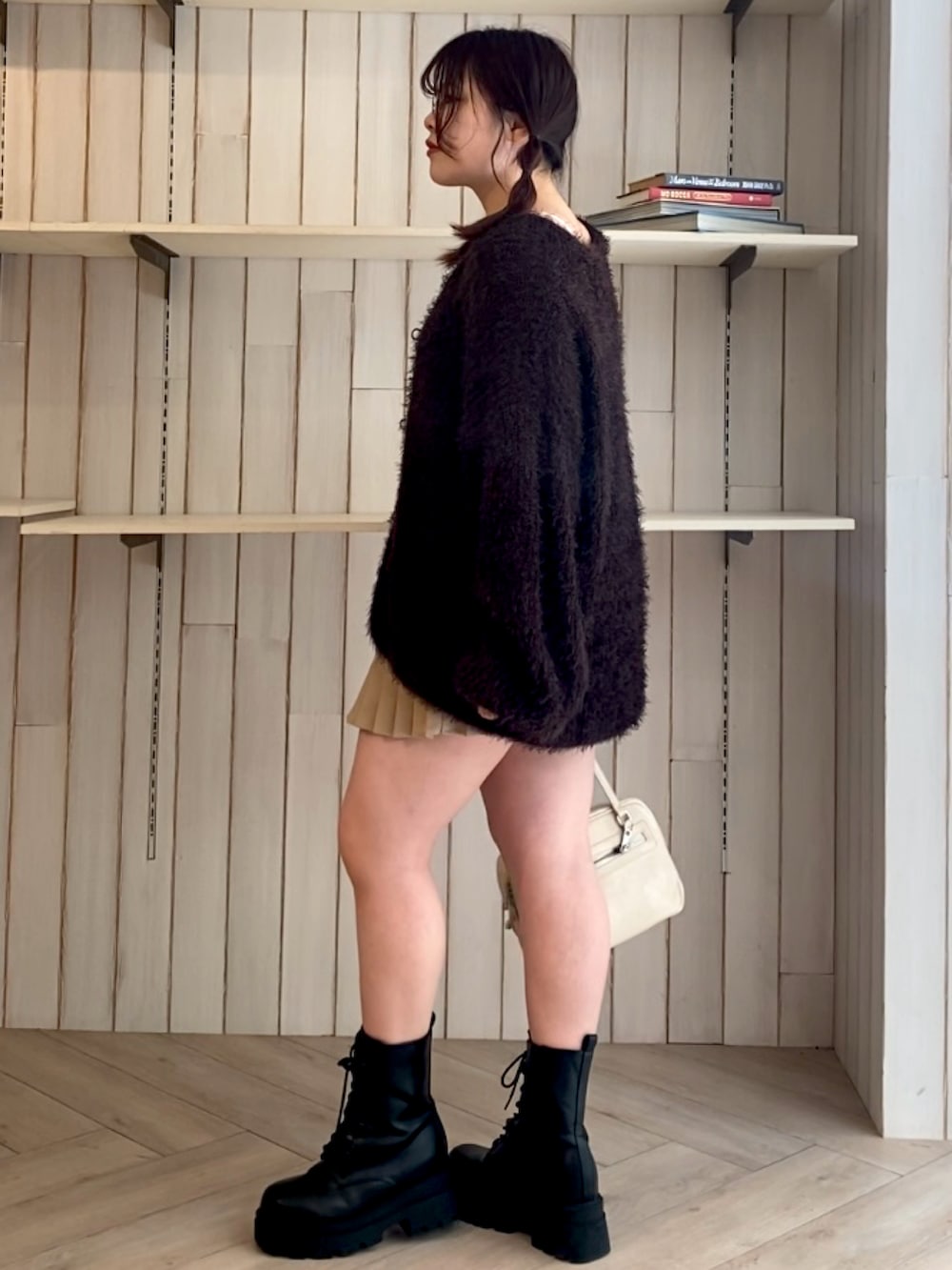 ブラウン系のカーディガン/ボレロ、ベージュ系のスカート、ホワイト系のショルダーバッグを着用したレディースの秋コーディネートの3枚目の写真