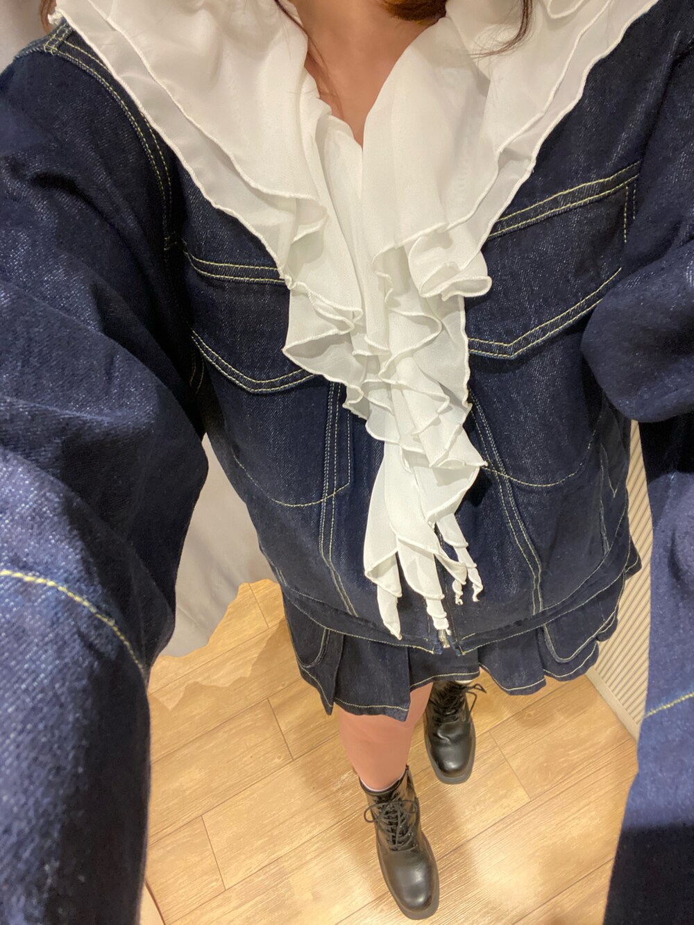 ブルー系のデニムジャケット、ブルー系のデニムスカート、ブラウン系のバッグを着用したレディースの冬コーディネートの2枚目の写真