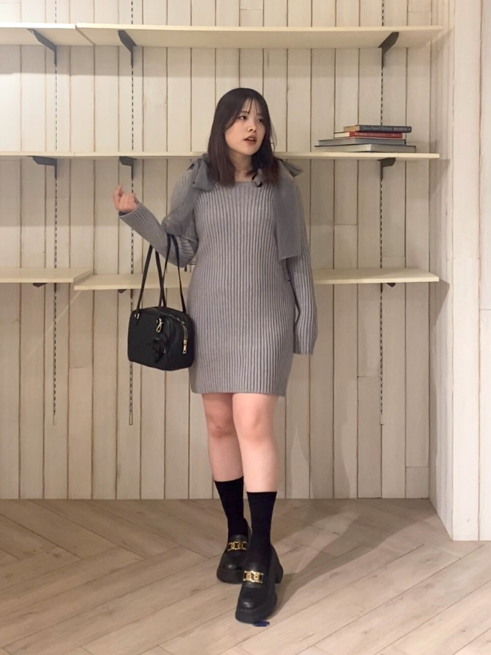 グレー系のワンピース、ブラック系のショルダーバッグを着用したレディースの秋コーディネートの2枚目の写真