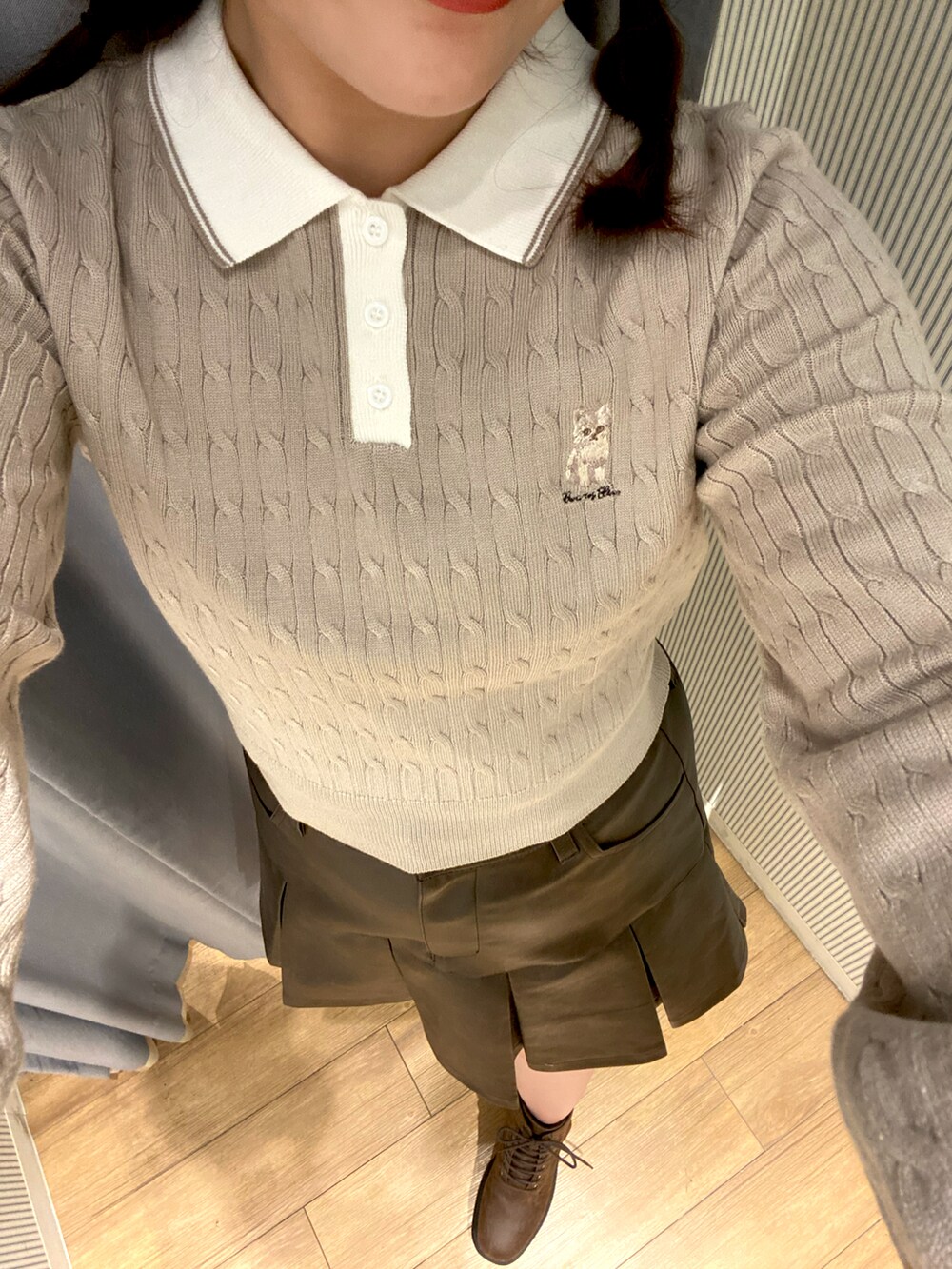 ブラウン系のスカート、ホワイト系のショルダーバッグ、ブラウン系のブーツを着用したレディースの秋コーディネートの3枚目の写真