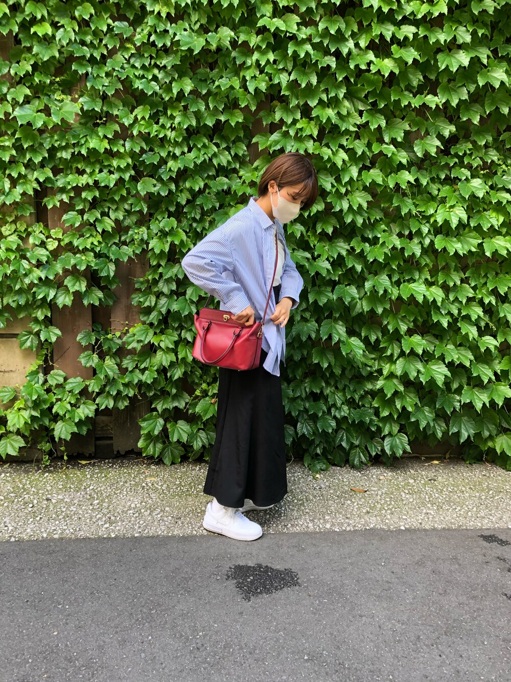 ブラック系のスカート、ホワイト系のスニーカー、ブルー系のシャツ/ブラウスを着用したレディースの夏コーディネートの4枚目の写真