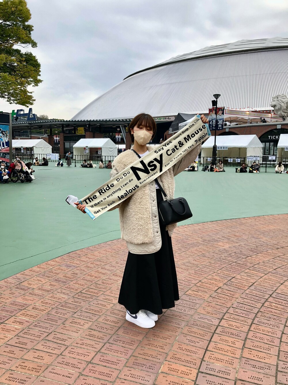 ホワイト系のジャケット/アウター、ホワイト系のスニーカー、ブラック系のスカートを着用したレディースの秋コーディネートの2枚目の写真