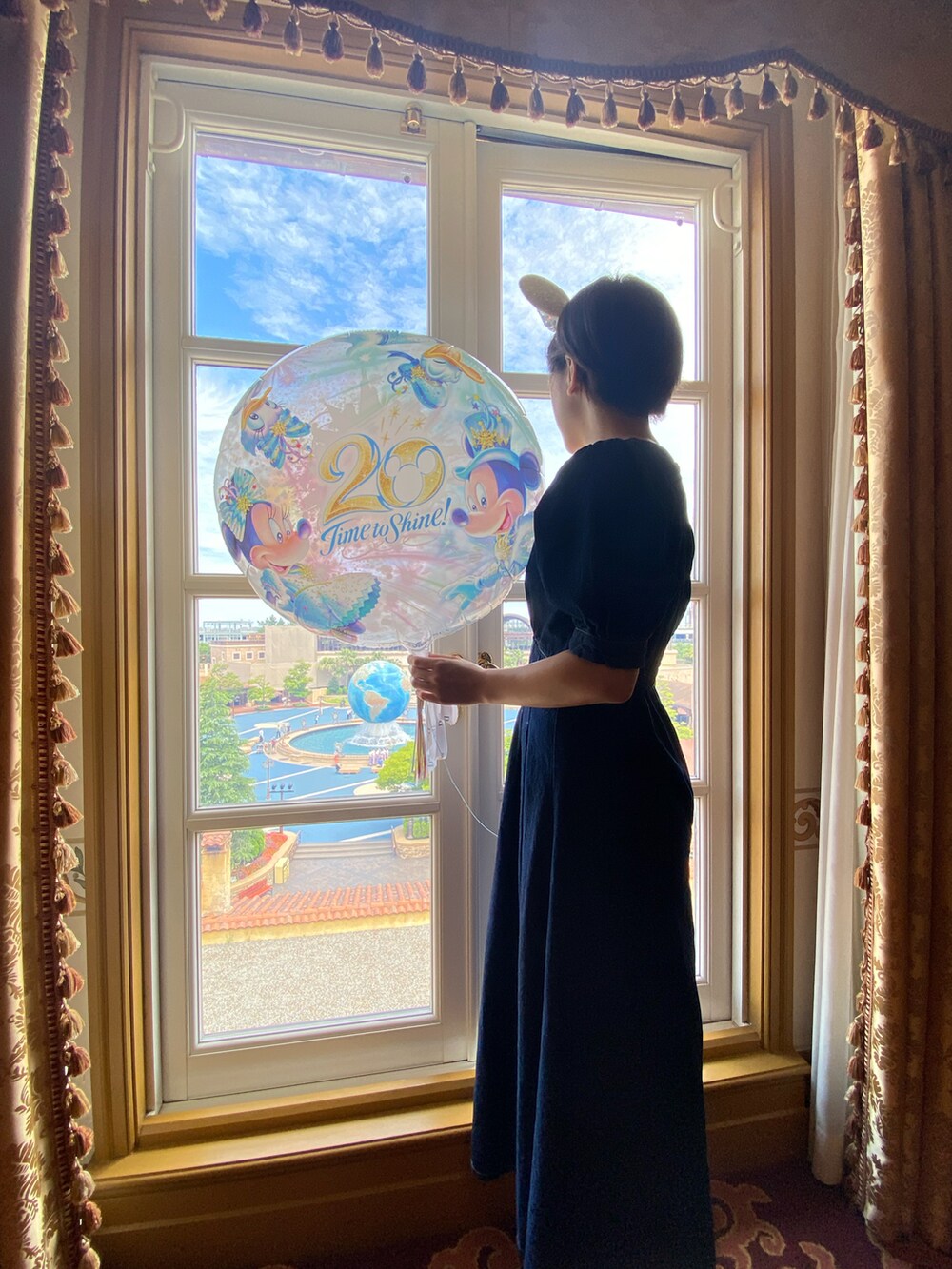 ブルー系のワンピース、ホワイト系のスニーカー、ベージュ系のショルダーバッグを着用したレディースの夏コーディネートの2枚目の写真