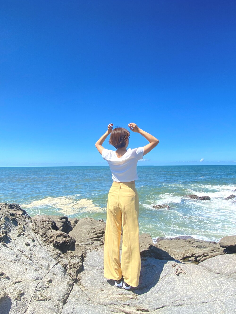 ホワイト系のTシャツ/カットソー、ブラック系のサンダル、イエロー系のその他パンツを着用したレディースの夏コーディネートの2枚目の写真