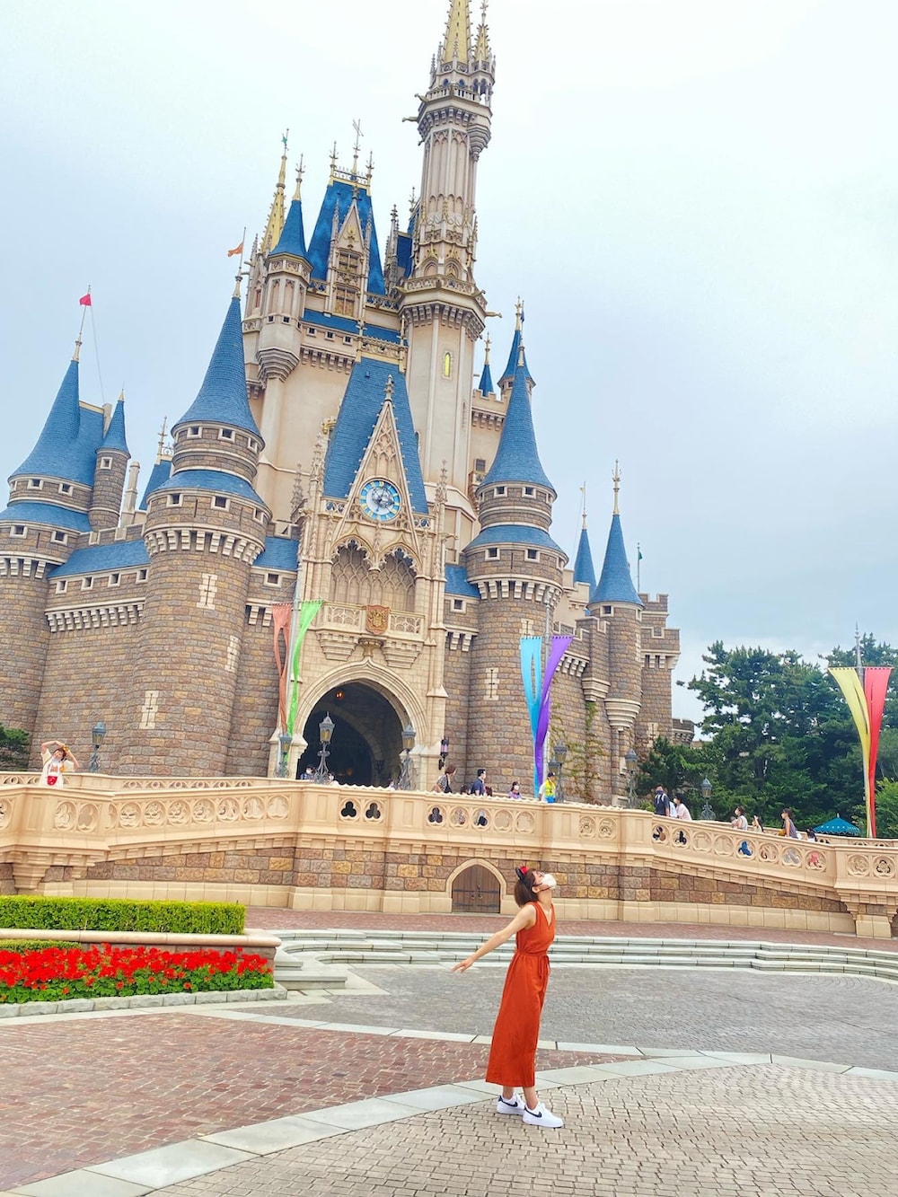 オレンジ系のワンピース、ホワイト系のスニーカーを着用したレディースの夏コーディネートの3枚目の写真