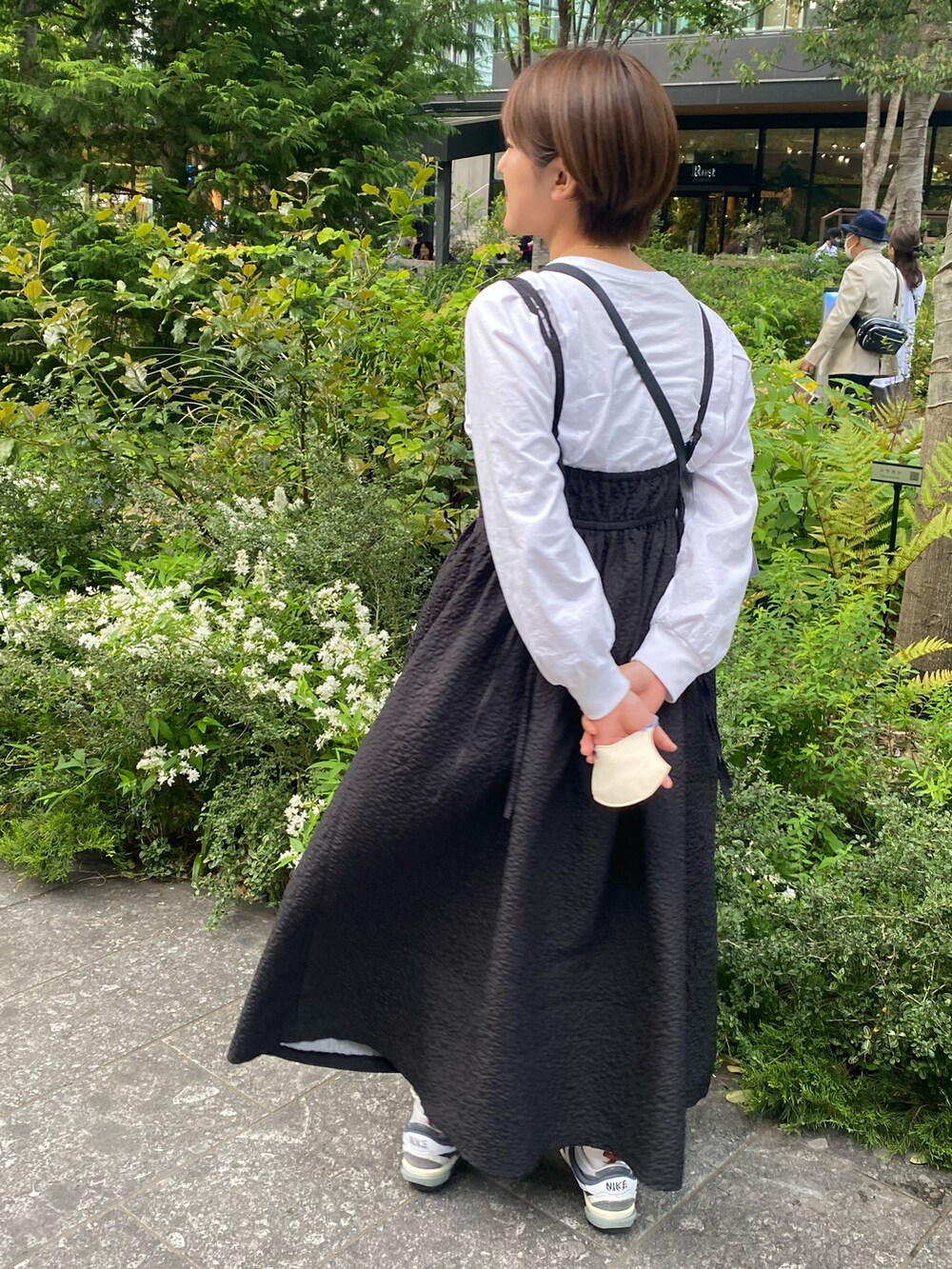 ブラック系のワンピース/ドレス、ブラック系のショルダーバッグ、ホワイト系のシャツ/ブラウスを着用したレディースの春コーディネートの2枚目の写真