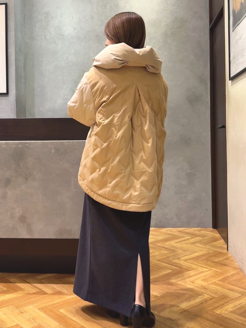 ベージュ系のダウンジャケット/コート、グレー系のスカートを着用したレディースの秋コーディネートの2枚目の写真