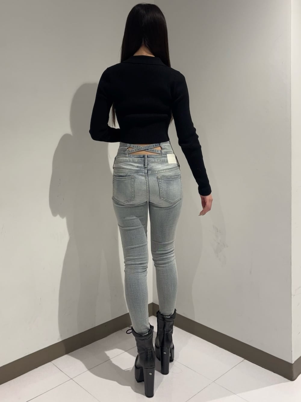 ブラック系のニット/セーター、ブルー系のデニムパンツ、ブラック系のブーツを着用したレディースの冬コーディネートの3枚目の写真