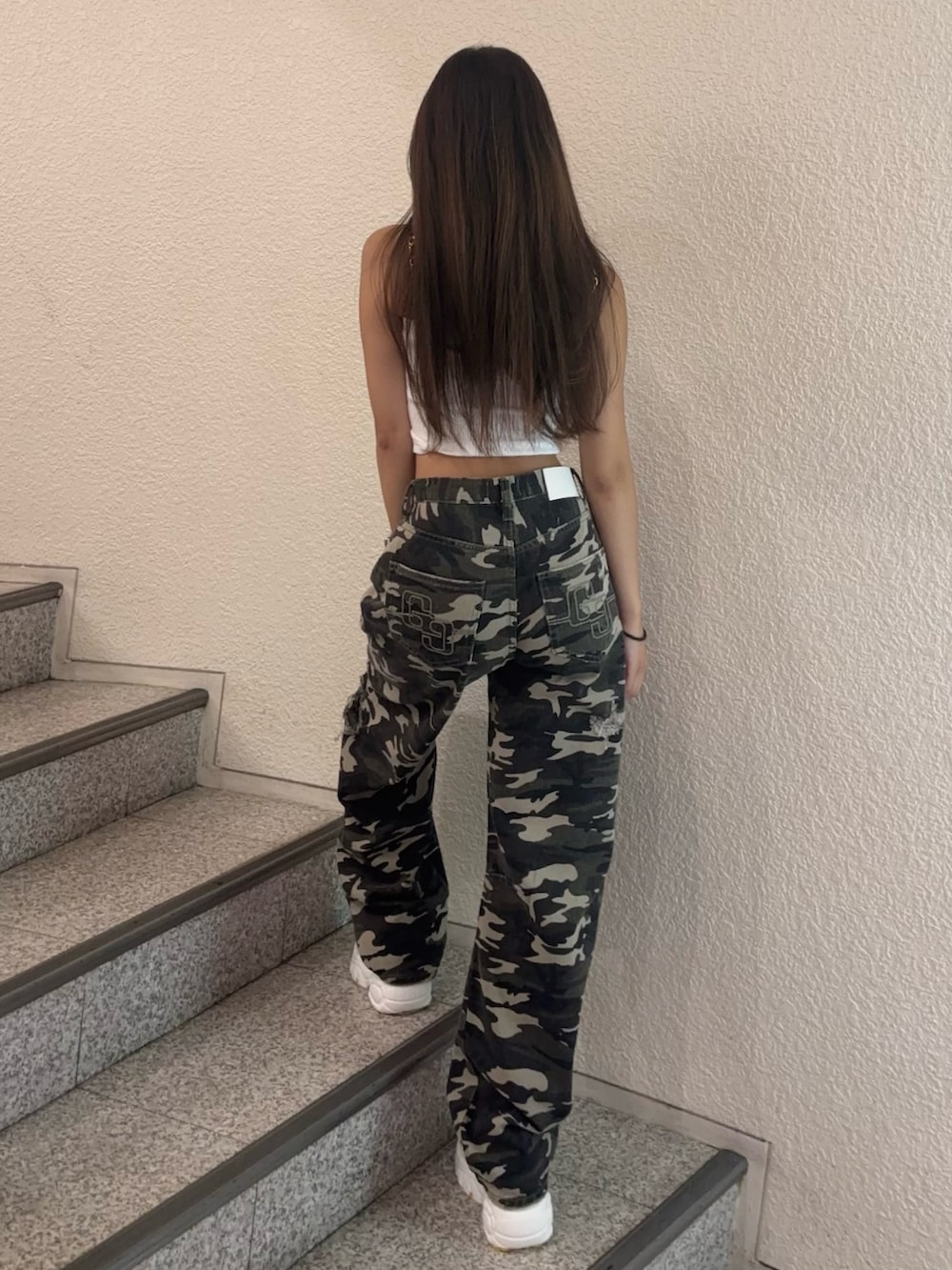 ホワイト系のキャミソール、ホワイト系のスニーカー、その他のデニムパンツを着用したレディースの夏コーディネートの3枚目の写真