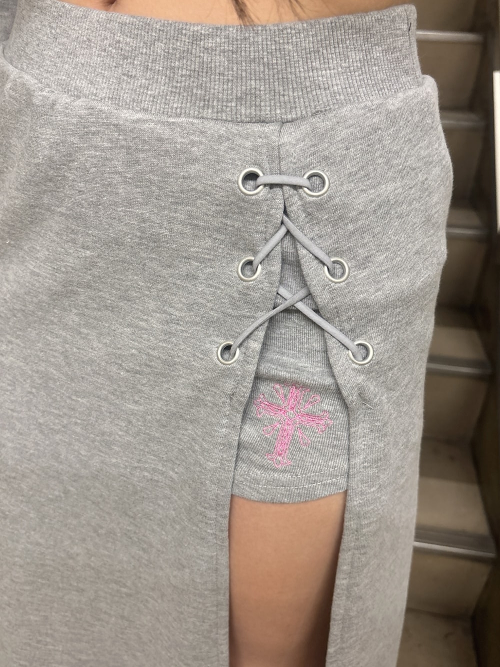 グレー系のスウェット、グレー系のスカート、ブラック系のサンダルを着用したレディースの冬コーディネートの4枚目の写真