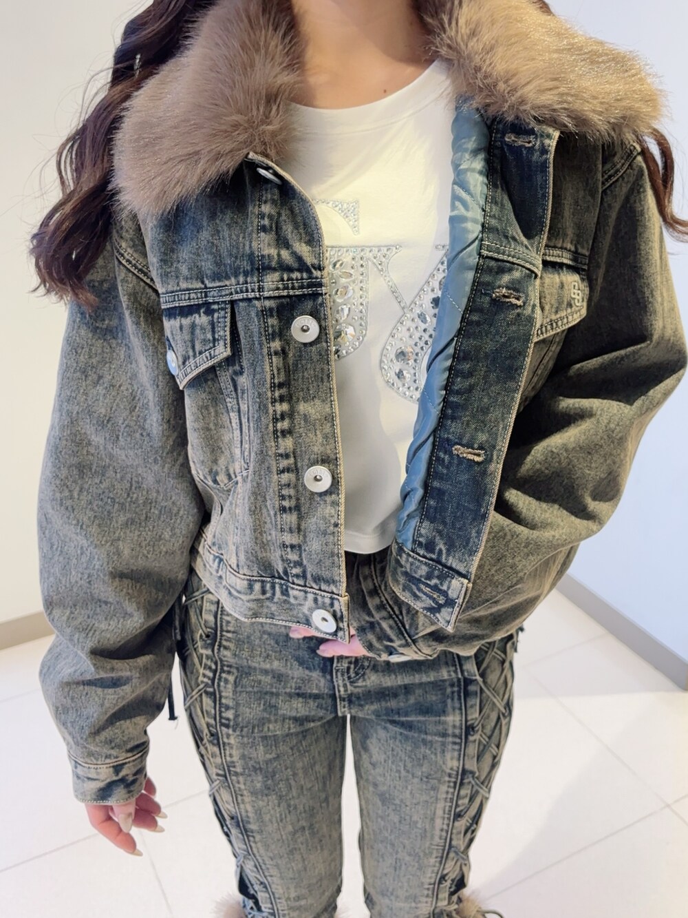 ブルー系のデニムジャケット、ブルー系のデニムパンツ、ブラック系のブーツを着用したレディースの秋コーディネートの4枚目の写真