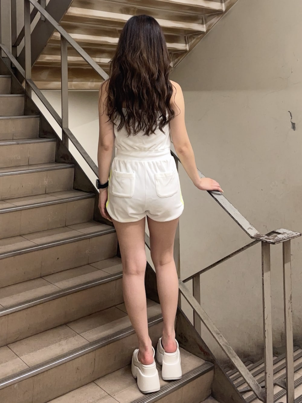 ホワイト系のワンピース、ホワイト系のサンダル、ブラック系のブラジャーを着用したレディースの夏コーディネートの3枚目の写真