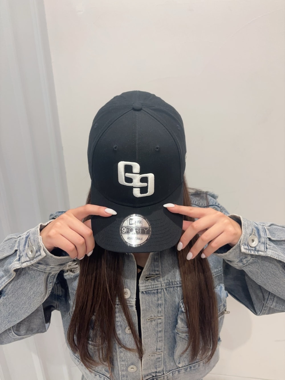 ブラック系のキャミソール、ブルー系のデニムスカート、ブルー系のデニムジャケットを着用したレディースの秋コーディネートの5枚目の写真