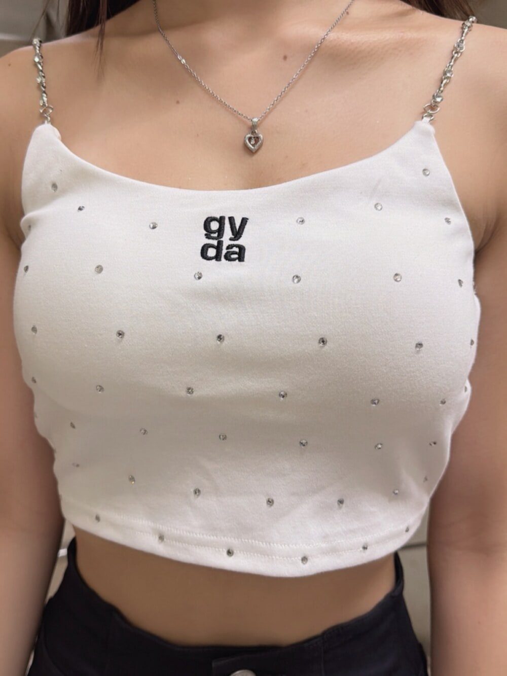 ホワイト系のサンダル、ホワイト系のキャミソール、ブラック系のデニムパンツを着用したレディースの夏コーディネートの4枚目の写真