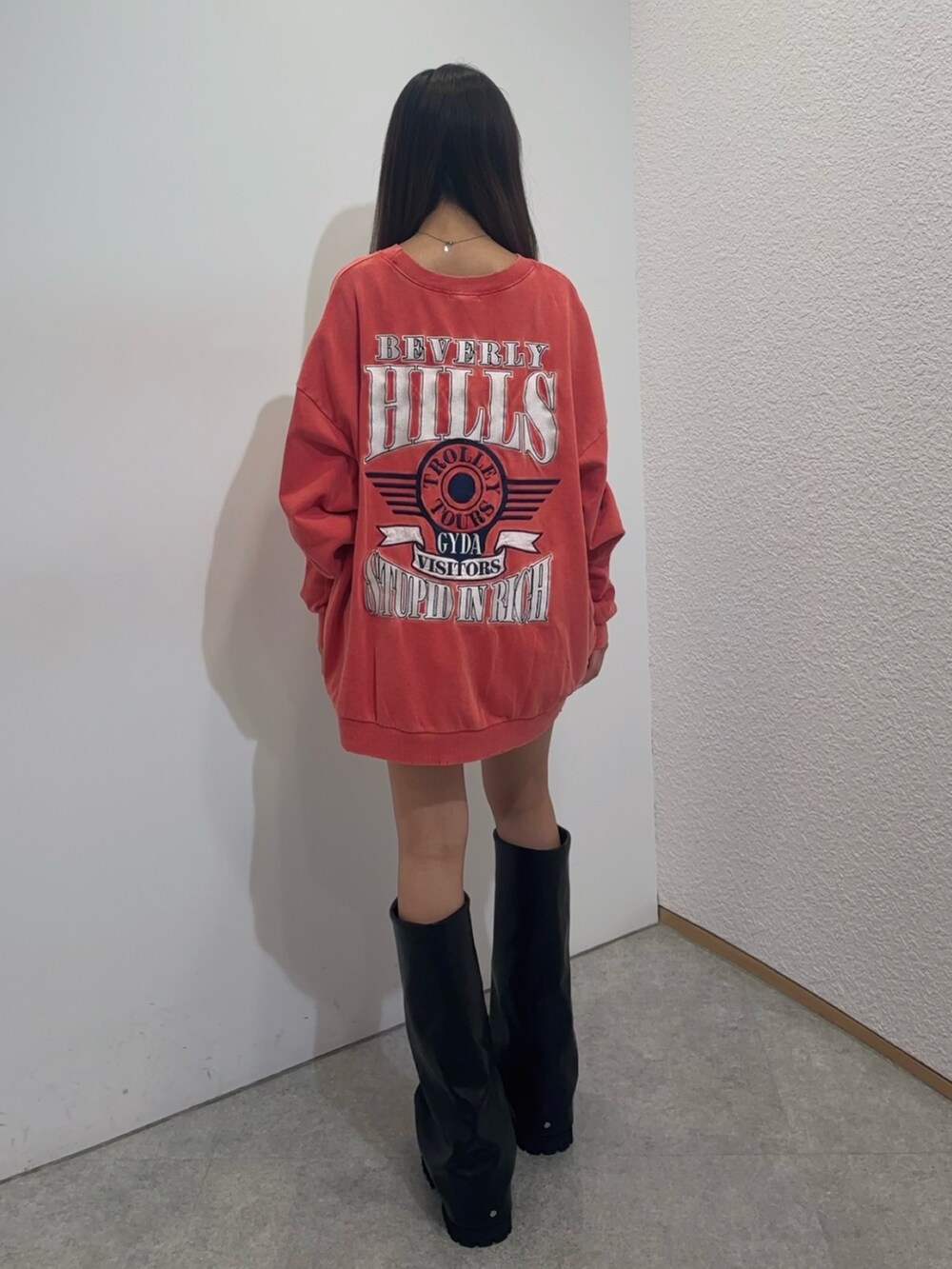 レッド系のスウェット、グリーン系のその他パンツ、ブラック系のブーツを着用したレディースの夏コーディネートの3枚目の写真