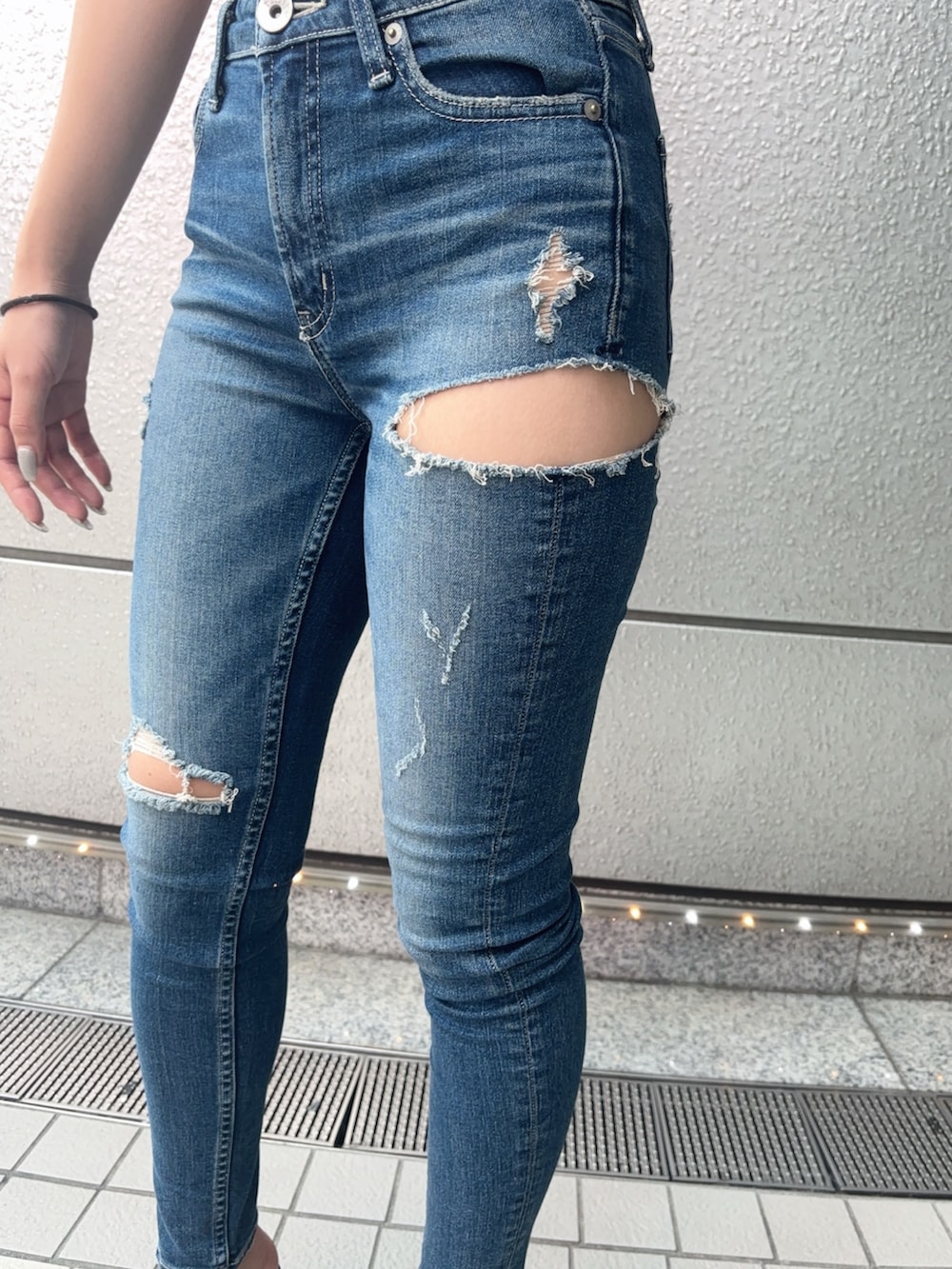 ブラック系のTシャツ/カットソー、ブルー系のデニムパンツ、ブラック系のサンダルを着用したレディースの夏コーディネートの4枚目の写真