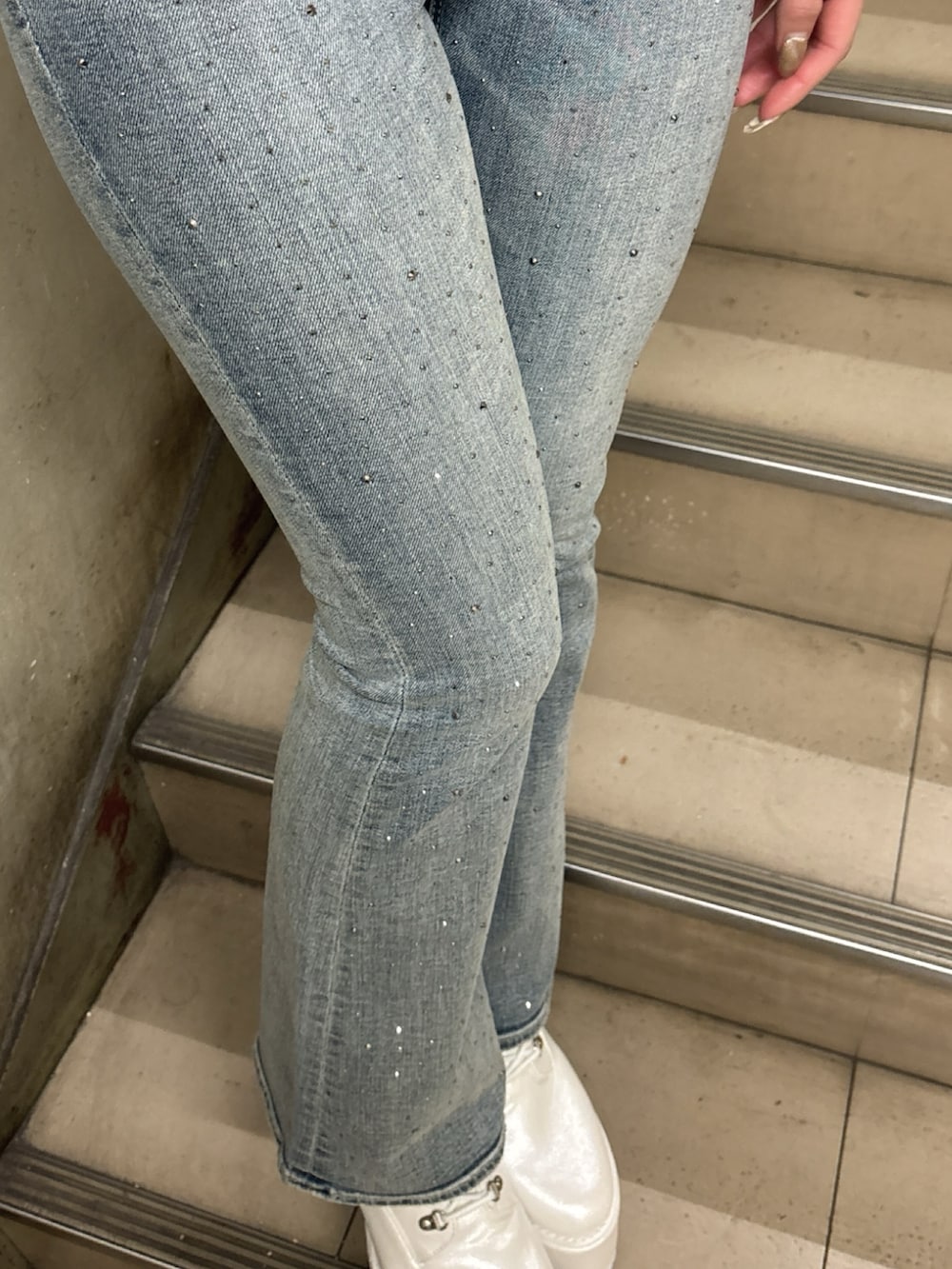 ホワイト系のニット/セーター、ブルー系のデニムパンツ、ホワイト系のブーツを着用したレディースの冬コーディネートの4枚目の写真